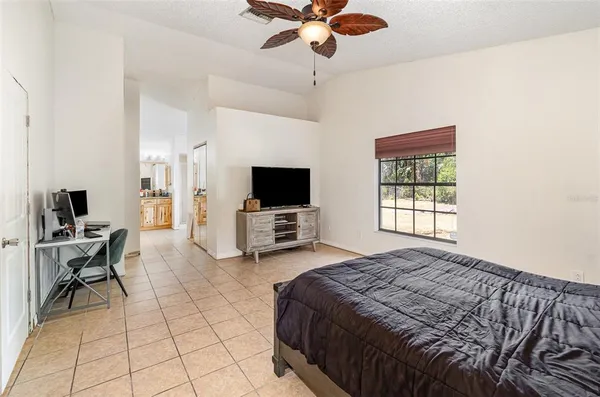 a spacious bedroom with a bed and a flat screen tv