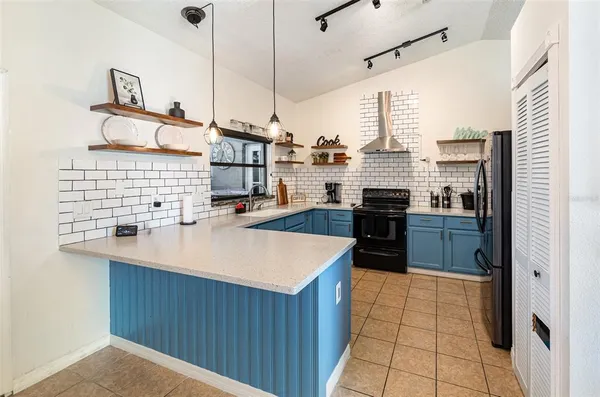 a kitchen with kitchen island granite countertop a sink counter top space appliances and cabinets