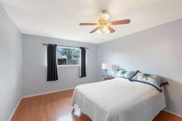 a bedroom with furniture and a chandelier fan