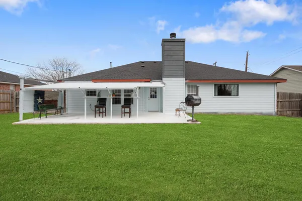 a view of a house with a yard and large tree