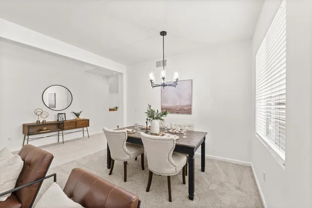 a dining room with furniture a chandelier and wooden floor