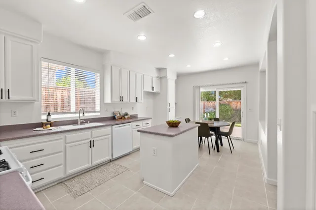 a kitchen with cabinets appliances a sink and a window
