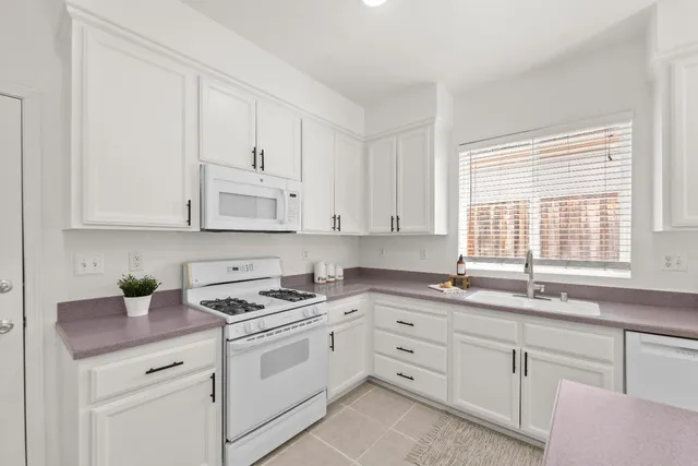 a kitchen with a sink a stove cabinets and counter space