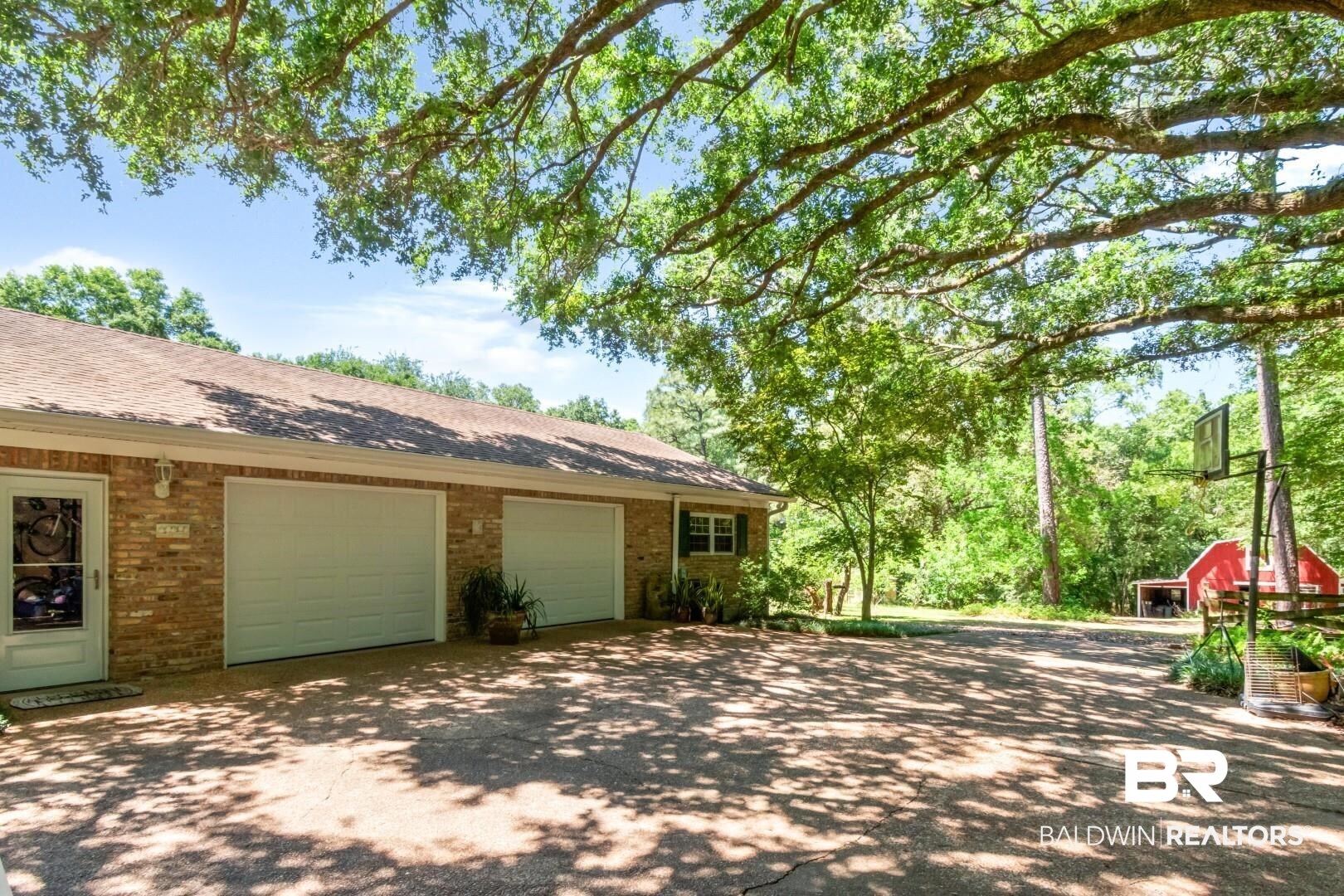 8220 Fordham Road Mobile, AL 36619 - Photo 26 of 41 View of side of property with driveway, brick siding, and an attached garage