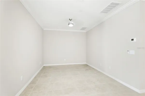 an empty room with a window and ceiling fan