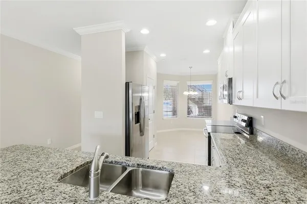 a kitchen with stainless steel appliances granite countertop a sink refrigerator and cabinets