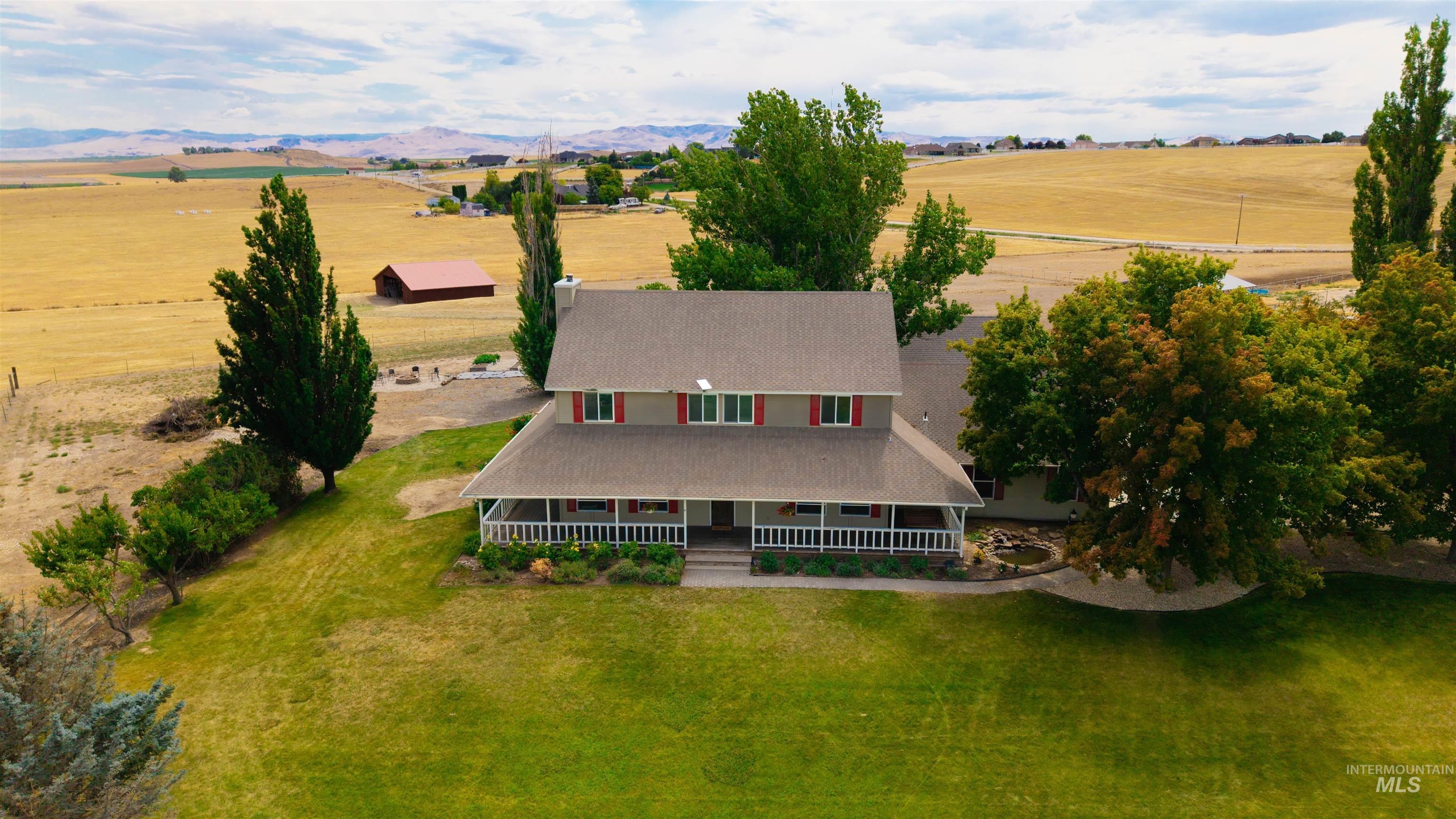 12369 Deer Flat Road Nampa, ID 83686 - Photo 3 of 50 Expansive covered porch featuring wood-finish decking and white railing, offering outdoor living space