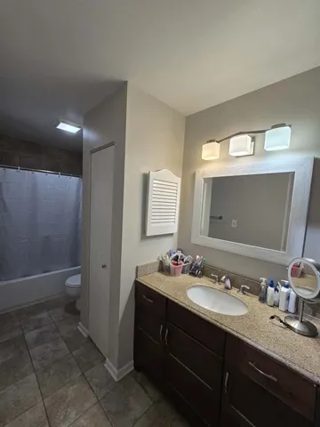 a bathroom with a granite countertop sink and a mirror