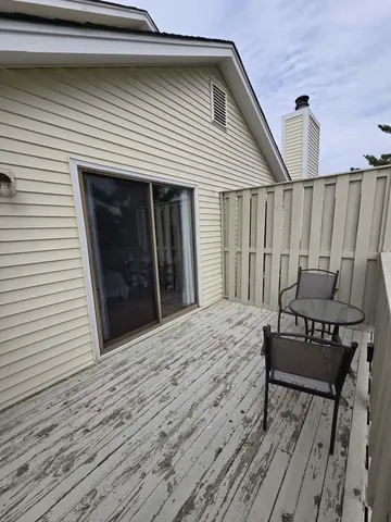a view of a roof deck with wooden floor and fence