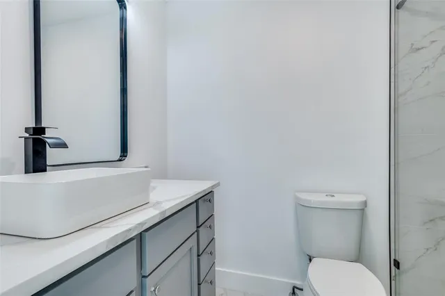 a bathroom with a sink a toilet and mirror