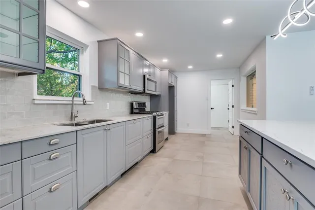 a kitchen with white cabinets and window