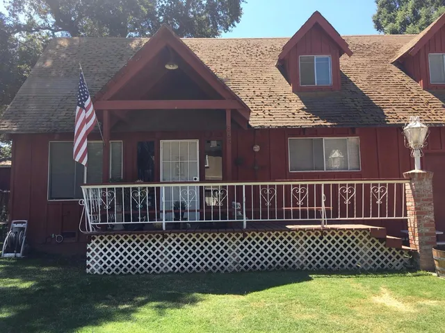 a view of a brick house with a wooden fence