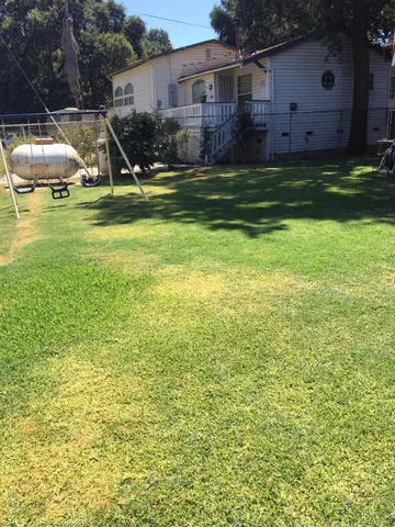 a view of a house with a yard and sitting area