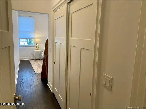 a view of a hallway with wooden floor and a cabinet