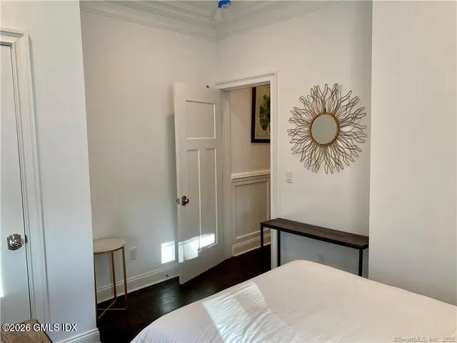 a bedroom with a bed and a painting on the wall