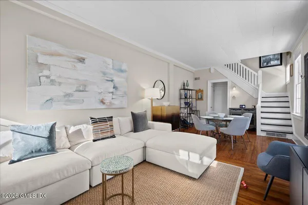 a living room with furniture and wooden floor