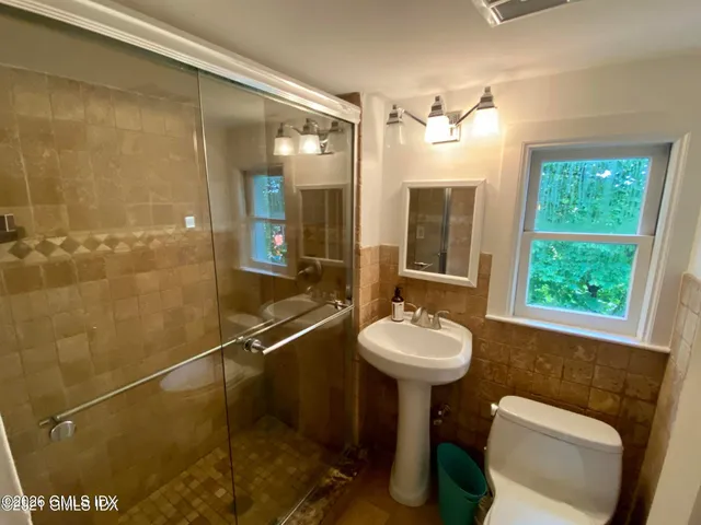 a bathroom with a sink mirror toilet and shower