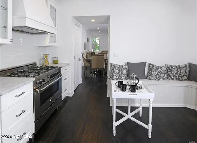 a kitchen with stainless steel appliances a dining table chairs and stove