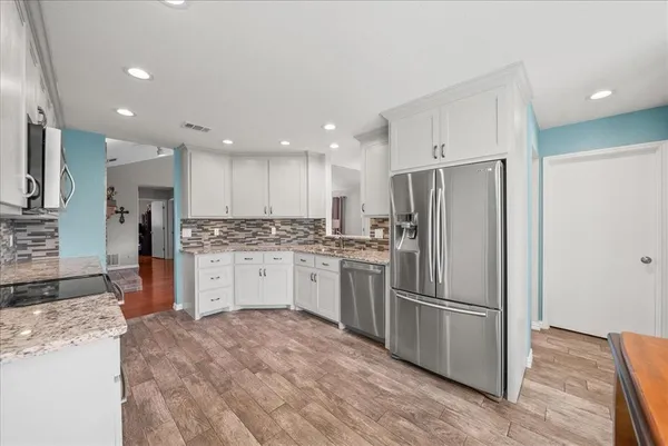 a kitchen with a refrigerator sink and cabinets