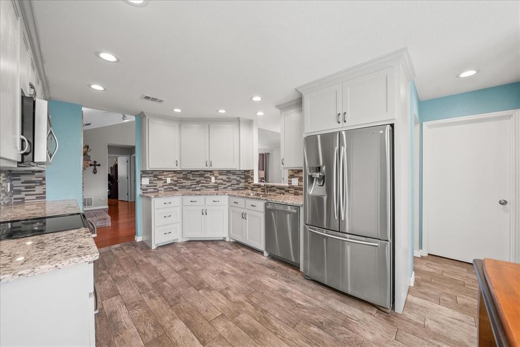 a kitchen with a refrigerator sink and cabinets