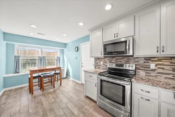 a kitchen with wooden floors and appliances