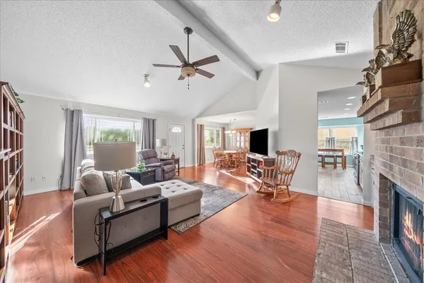 a living room with fireplace furniture and a wooden floor