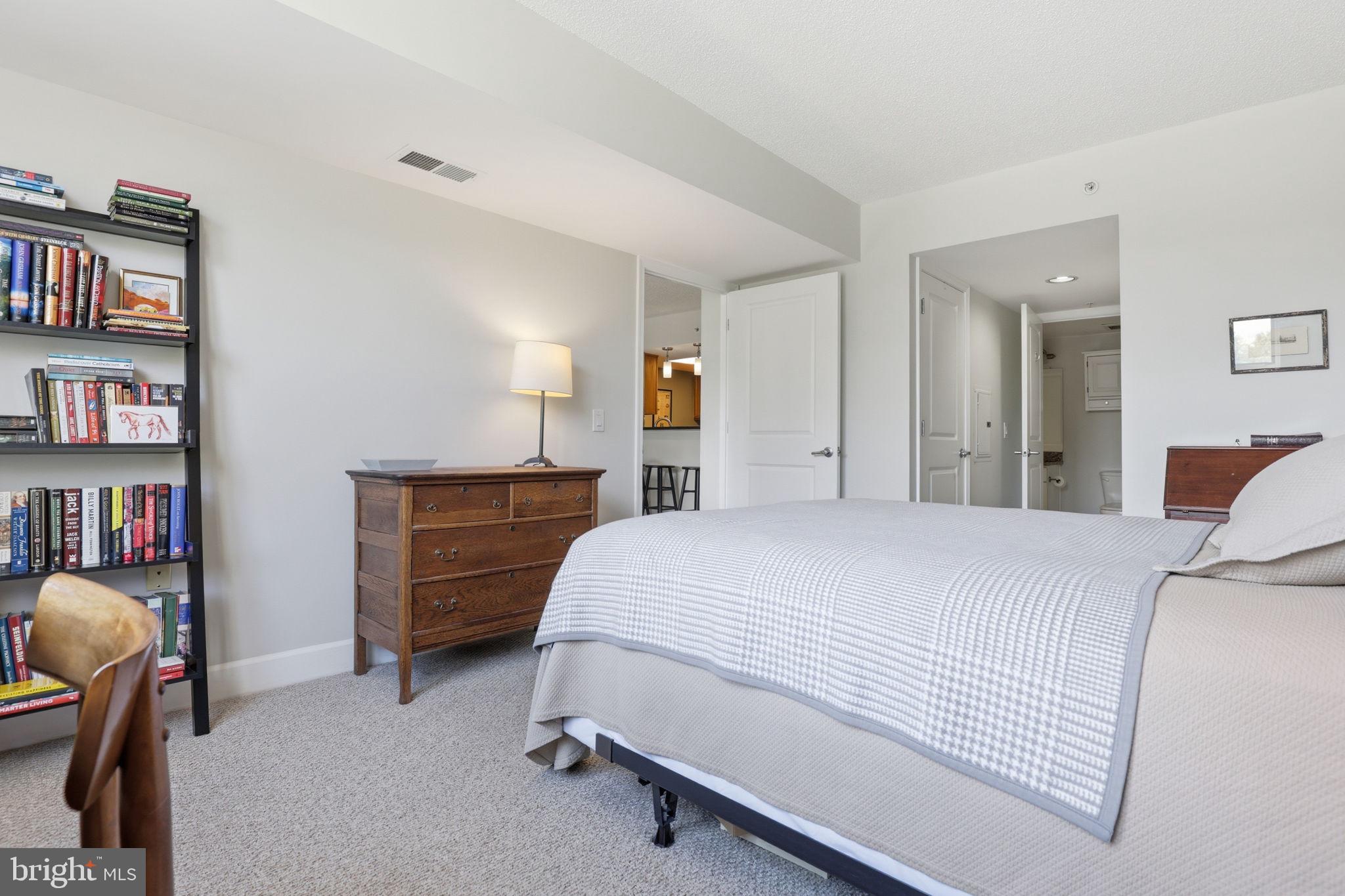 11800 Sunset Hills Road, Unit 218 Reston, VA 20190 - Photo 22 of 38 a bedroom with a bed and a book shelf