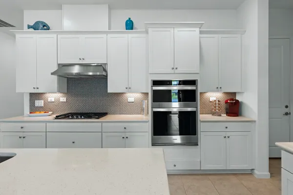 a kitchen with stainless steel appliances granite countertop white cabinets and a stove
