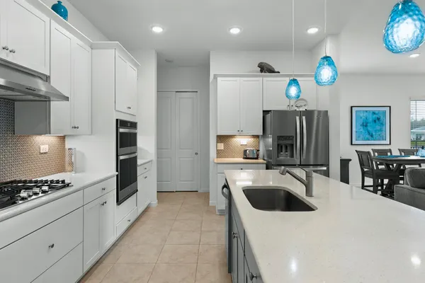 a kitchen that has a refrigerator a sink and a stove