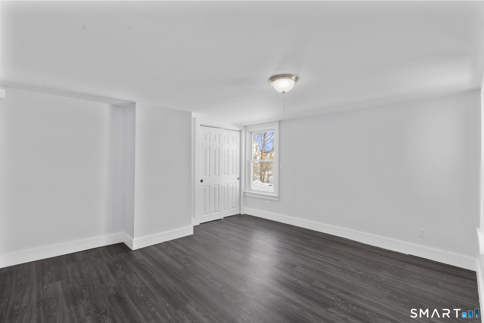 59 Pine Street Hamden, CT 06514 - Photo 11 of 36 a view of an empty room with wooden floor and a window