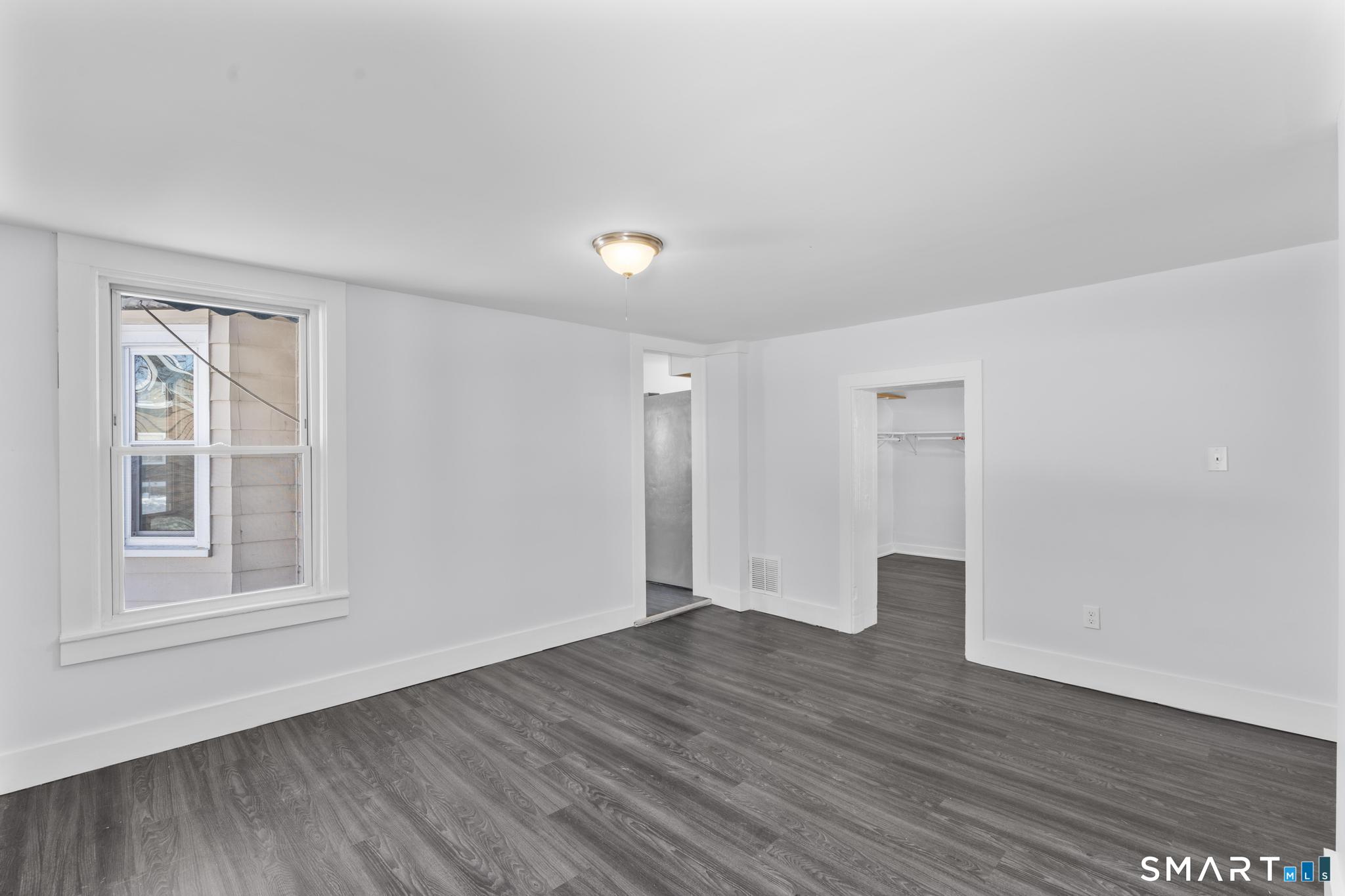 59 Pine Street Hamden, CT 06514 - Photo 12 of 36 a view of an empty room with wooden floor and windows