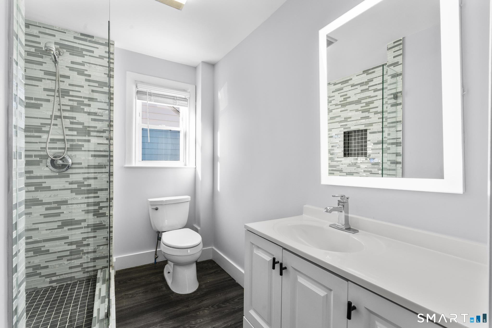 59 Pine Street Hamden, CT 06514 - Photo 16 of 36 a bathroom with a granite countertop sink a toilet and a window