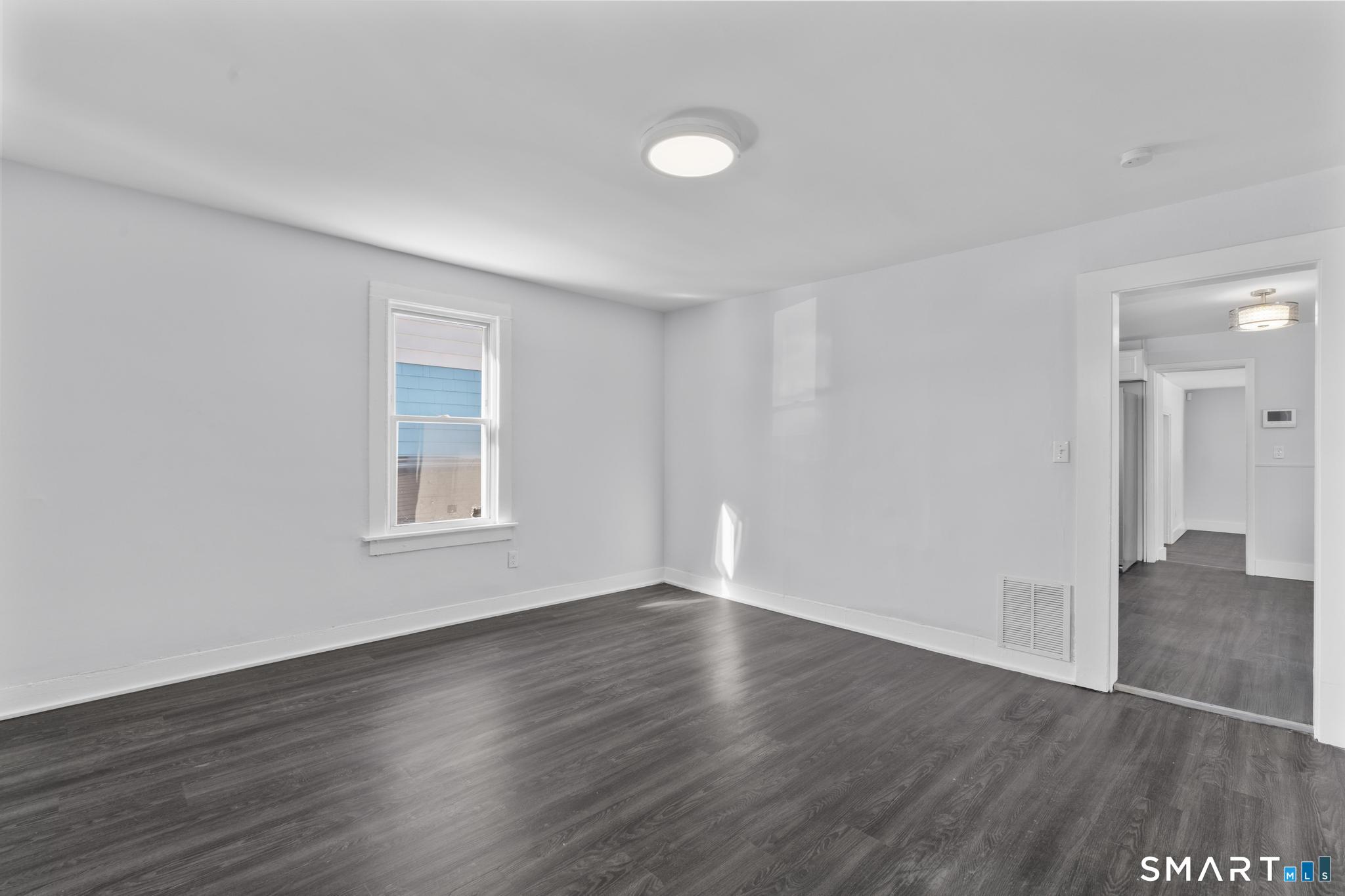 59 Pine Street Hamden, CT 06514 - Photo 2 of 36 a view of an empty room with wooden floor and a window
