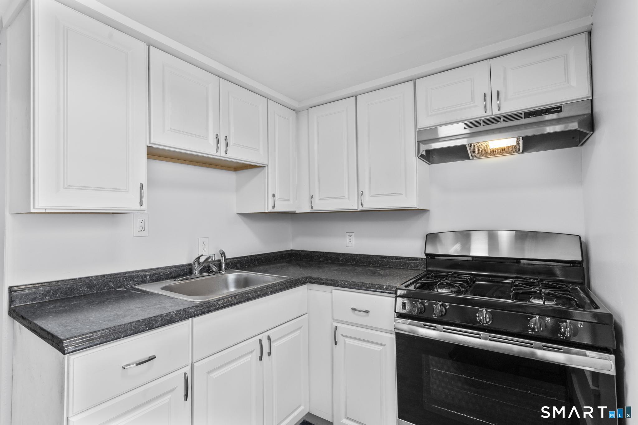 59 Pine Street Hamden, CT 06514 - Photo 21 of 36 a kitchen with white cabinets and appliances