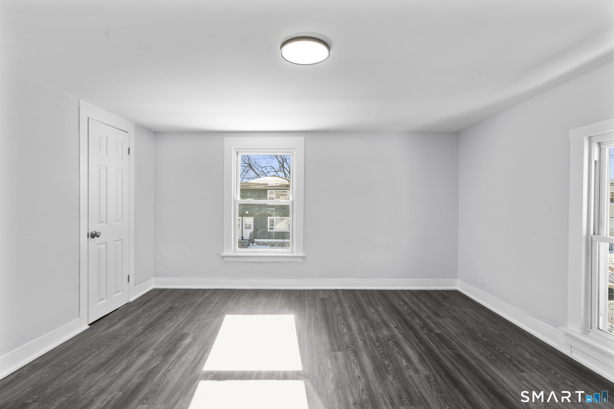 59 Pine Street Hamden, CT 06514 - Photo 26 of 36 an empty room with wooden floor and windows