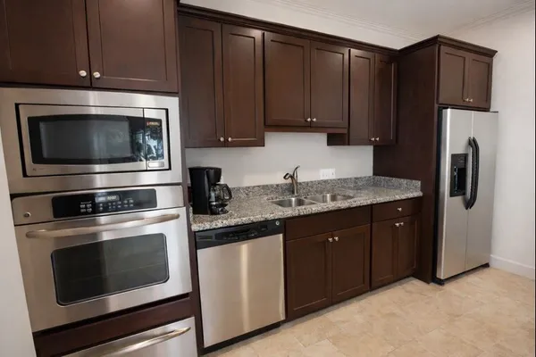 a kitchen with granite countertop wooden cabinets and stainless steel appliances
