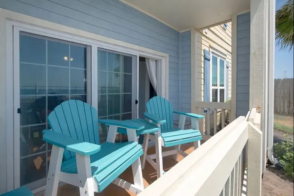 a balcony with chairs and a potted plant