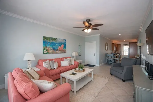 a living room with furniture ceiling fan and a rug