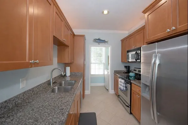 a kitchen with granite countertop a refrigerator and a sink