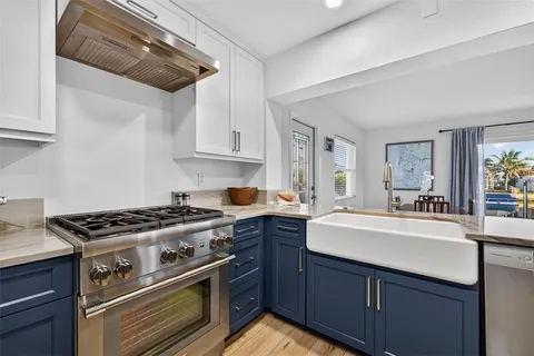 a kitchen with stainless steel appliances a refrigerator and wooden floor