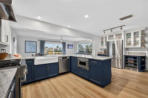a kitchen with a dining table chairs and wooden floor