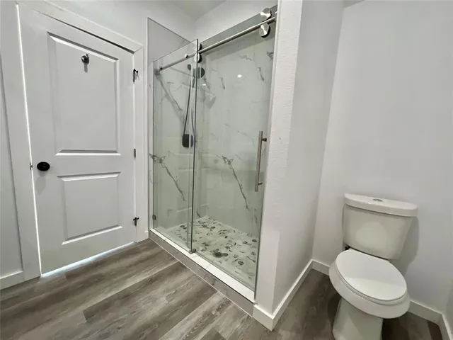 a bathroom with a granite countertop toilet and a shower