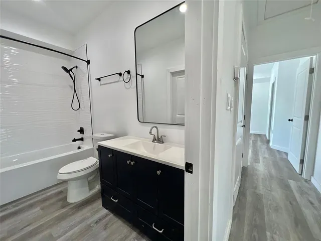 a bathroom with a double vanity sink toilet mirror and bathtub