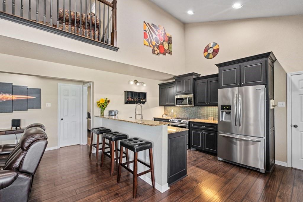 455 County Road 2808 Mabank, TX 75147 - Photo 14 of 40 a kitchen with stainless steel appliances granite countertop a refrigerator a stove a sink and chairs with wooden floor