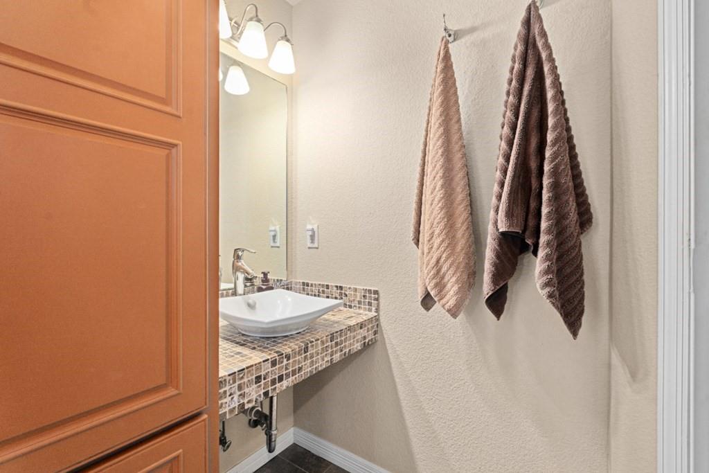455 County Road 2808 Mabank, TX 75147 - Photo 22 of 40 a bathroom with a granite countertop sink and a mirror