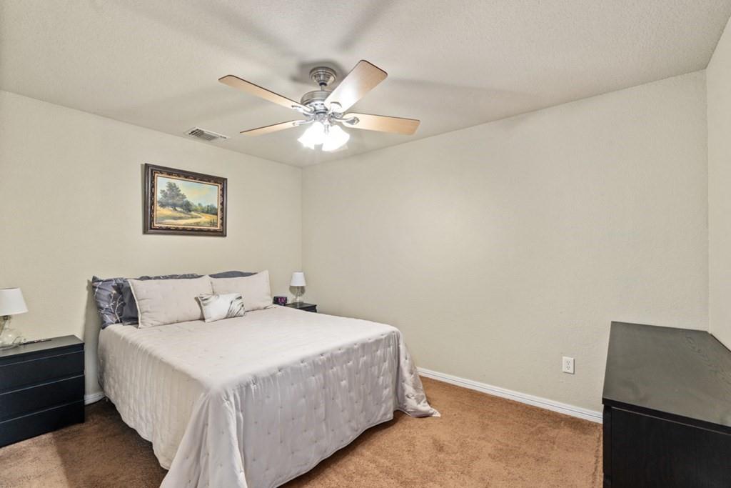 455 County Road 2808 Mabank, TX 75147 - Photo 24 of 40 a bedroom with a large bed and a ceiling fan