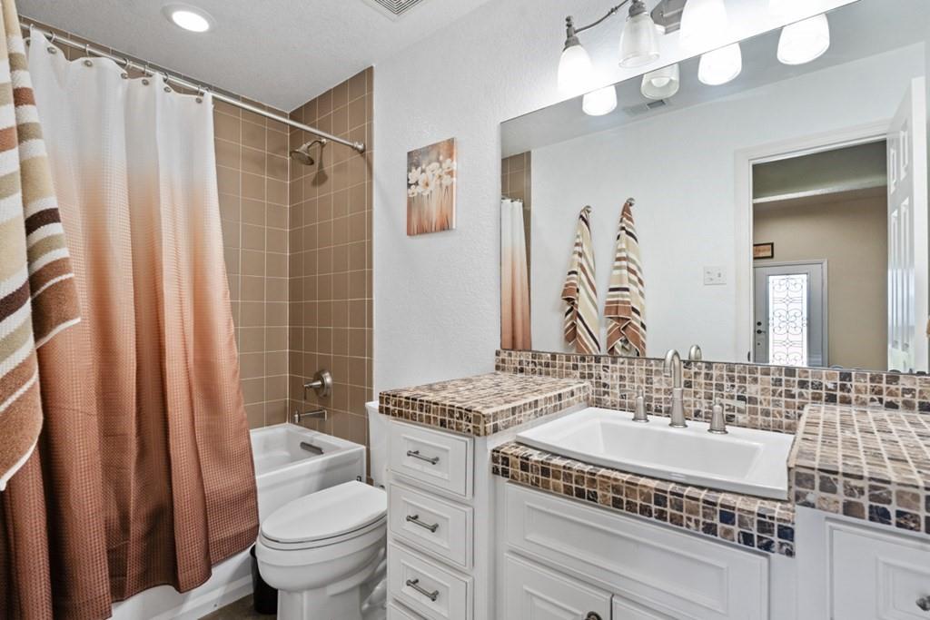 455 County Road 2808 Mabank, TX 75147 - Photo 25 of 40 a bathroom with a sink a toilet a mirror a vanity and shower