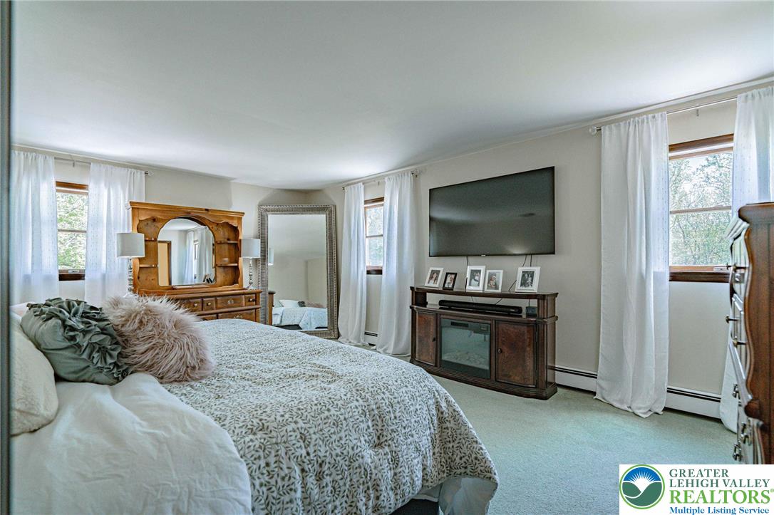 3857 Friedens Road Slatington, PA 18080 - Photo 37 of 75 This spacious bedroom offers ample natural light through multiple windows, creating a bright and airy retreat.