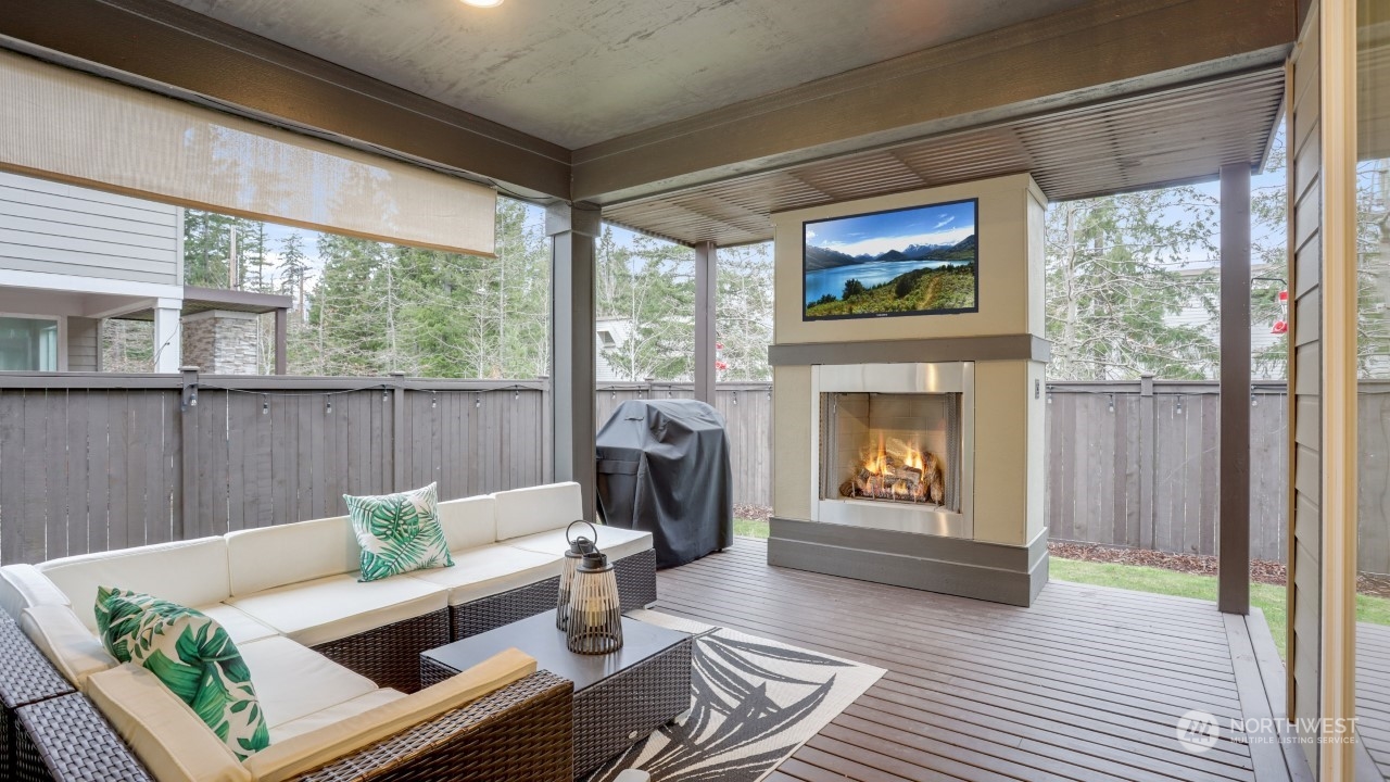 23922 Southeast 258th Way Maple Valley, WA 98038 - Photo 24 of 30 a living room with furniture a fireplace and a large window