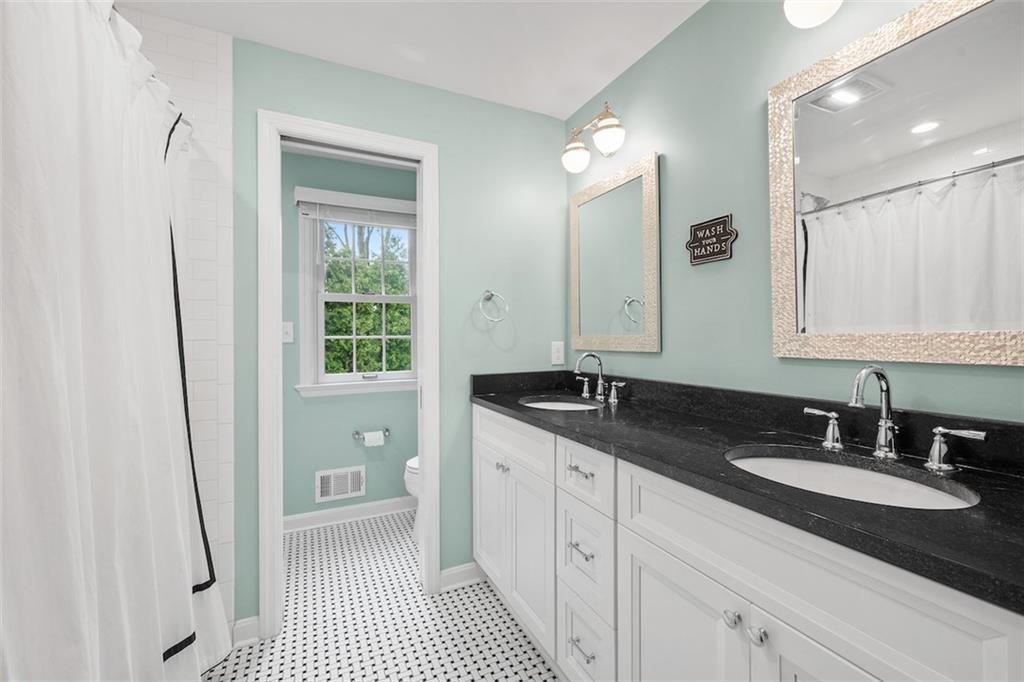 1014 Osage Road Pittsburgh, PA 15243 - Photo 34 of 49 a bathroom with a granite countertop sink a toilet a shower and a mirror